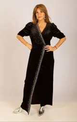 Vestido largo de terciopelo negro con escote en V, mangas 3/4 abullonadas y detalle de strass plateados en diagonal desde el hombro hasta la abertura de la falda.