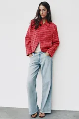 Blazer cruzado de tweed rojo con patrón texturizado en tonos blanco y negro, cuello con solapa, manga larga y cierre frontal con un botón.