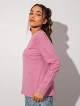 Remera negra de manga larga, corte holgado, con detalle fruncido en el cuello y bolsillo en el pecho.