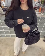 Buzo de cuello redondo con efecto stone wash, confeccionado en tejido de algodón y poliéster con interior de felpa. Presenta un corte regular, puños y cintura acanalados, y el logo de la marca estampado en el pecho.