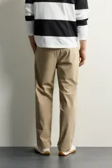Pantalón regular fit de hombre color negro, confeccionado en tejido técnico ligero con cintura elástica, bolsillos frontales, bolsillos traseros de vivo y cierre frontal con cremallera y botón.