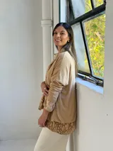 Sweater de punto color arena con diseño de capas que incluye una camisa inferior y un pañuelo a juego, ambos con estampado animal print en tonos tierra.