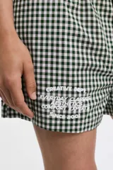 Short de tela a cuadros celeste y blanco con cintura elástica y bolsillos laterales.