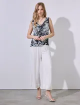 Blusa sin mangas de gasa estampada en tonos negro, blanco y celeste. Escote en V tanto en la parte delantera como en la espalda.