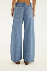 Pantalón de jean de tiro medio y corte wide leg, confeccionado en denim lavado de color celeste. Presenta diseño de perneras amplias, bolsillos funcionales y cierre frontal con botón y cremallera.