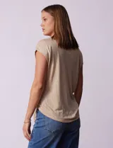 Blusa color beige de modal con escote en V, abertura central con botones y ruedo anudado. Marca French Laundry.