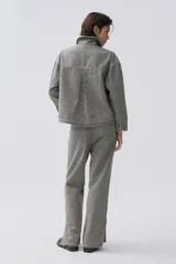 Campera de denim 100% algodón a rayas verticales en tonos grisáceos y azules. Cuenta con cuello camisero, cierre frontal con botones plateados y cuatro bolsillos frontales con botón.