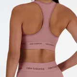 Top deportivo de sujeción media con diseño estilo jersey y banda elástica inferior con logo de la marca. Confeccionado con tecnología de secado rápido.