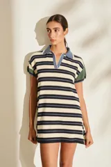 Vestido tipo polo tejido de punto liviano a rayas horizontales en tonos beige, azul marino y verde. Presenta cuello polo en color azul, mangas cortas con detalles en verde y calce holgado.