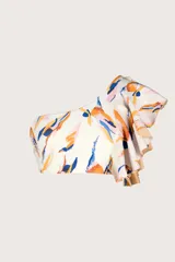 Top de bikini asimétrico, color blanco hueso, con estampado abstracto en tonos naranja, azul y rosado. Presenta un volado amplio en el hombro derecho y tirantes finos ajustables.