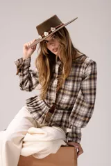 Blusa de tartán con diseño versátil, confeccionada en tela escocesa con detalles en cuero de oveja. Presenta cuello alto con forro de piel sintética, mangas largas con puños de cuero y piel, y un ruedo tableado con ajuste de cinturón de cuero en la cintura.