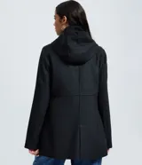 Campera alargada de polivelour color beige, con capucha, cierre frontal con botones a presión y bolsillos con solapa. Presenta un diseño de corte recto y manga larga.