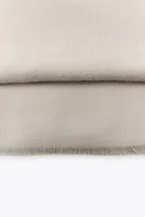 Pañuelo rectangular de color marrón oscuro, con textura suave y terminaciones deshilachadas en los extremos.