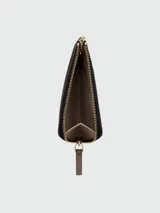 Billetera Marc Jacobs The Top Zip Multi Wallet de cuero negro granulado, con cierre superior dorado y la inscripción "THE WALLET MARC JACOBS" grabada en relieve en el frente.