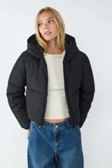 Campera puffer de corte recto y diseño acolchado, con capucha fija, manga larga y cierre frontal con cremallera.