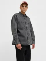 Camisa de denim negra de manga larga con cuello clásico y cierre con botones. Diseño amplio con bolsillos en el pecho.