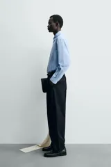 Camisa de algodón celeste con rayas verticales finas en blanco, de corte relajado (relaxed fit), cuello solapa y manga larga con puño abotonado.