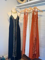 Vestido largo color salmón con escote en V, breteles finos y bordados con lentejuelas en el frente.