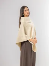 Poncho de tejido texturizado en color marrón chocolate, con cuello amplio y diseño asimétrico.