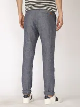 Pantalón de lino color verde oliva, de corte recto y con ruedo arremangado.