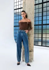 Jeans de mujer tiro alto, confeccionado en denim azul, de corte holgado tipo jogger con puños fruncidos en los tobillos.