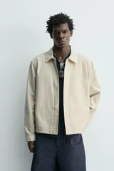 Sobrecamisa de corte regular fit en color beige, confeccionada en popelín de algodón. Cuenta con cuello solapa, manga larga con puño abotonado, bolsillos ocultos en las costuras de la cadera y cierre frontal con botonadura oculta.