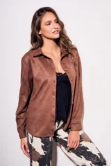 Camisa color marrón de gamuza sintética, de corte recto, con cuello clásico, cierre frontal con botones y mangas largas.
