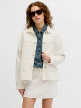 Chaqueta de denim en color crudo, con cierre frontal de botones metálicos, bolsillos frontales aplicados y cuello camisero.