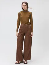 Pantalón de tiro medio y pierna ancha confeccionado en denim de algodón grueso. Presenta un diseño a rayas verticales en tonos azul y celeste, con costuras en contraste color rojo, bolsillos laterales tipo cargo y remaches metálicos.