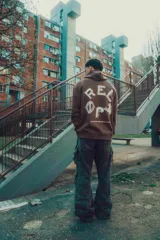 Hoodie color crema de corte oversize con capucha y logo pequeño en el pecho.