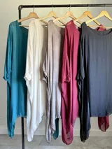 Vestido o blusón maxi de seda italiana color borgoña, con mangas amplias y forro de modal elastizado. Presenta un corte fluido y escote redondo.