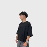Remera negra de corte boxy fit y tejido grueso, con mangas 3/4 y diseño minimalista que incluye el número "1999" estampado en el pecho en tono sutil.