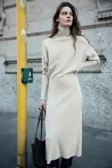 Bolso de hombro tipo maxi shopper, color beige claro, con pespuntes verticales en el cuerpo y doble asa. Incluye un bolso interior con cierre de cremallera metálica y cierre principal imantado.