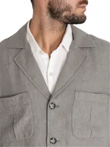 Chaqueta de lino orgánico color gris, tipo blazer con estilo cargo, cuello con solapa, cierre frontal de botones y múltiples bolsillos con fuelle en el pecho y la parte inferior.