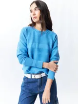 Mochila pequeña color rosa pálido con correas ajustables y asa superior. Tiene un bolsillo frontal con cierre y un parche con el logo de la marca en la parte inferior.