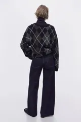 Jean wide leg de tiro alto en denim de algodón azul, con costuras frontales verticales y bolsillos simulados con solapa y botones en la parte delantera.