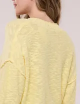 Cardigan blanco de punto liviano y texturado, de corte holgado y diseño casual. Cuenta con escote en V pronunciado, abotonadura frontal, mangas largas con hombros caídos y bolsillos delanteros tipo parche.