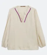 Blusa amplia color crema en viscosa con escote V con detalle de bordado en el escote, manga larga y elástico en el puño.