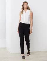 Pantalón de vestir negro de corte recto y entallado, con nervadura central vertical que estiliza la silueta. Presenta cintura ancha de soporte, panel de malla interna para control abdominal y bolsillos posteriores simulados.
