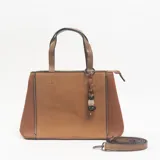 Cartera tipo tote color camel, con paneles laterales de textura granulada y panel central de tejido con textura diagonal. Incluye doble asa de mano, correa larga ajustable y extraíble, cierre superior y un dije colgante decorativo con cuentas de madera y piedra.