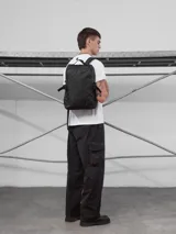 Mochila urbana de diseño minimalista en color negro, confeccionada en material tracker waterproof. Cuenta con compartimento principal amplio, espacio para notebook, bolsillo frontal de acceso rápido y cierres termosellados. Incluye espalda y correas acolchadas regulables.