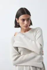 Top de tejido acanalado con sutil acabado metalizado, de silueta entallada con diseño peplum en la cintura y mangas largas levemente acampanadas.