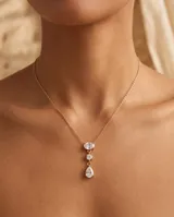 Collar de acero con baño de oro, diseño de tres circonias colgantes: una ovalada en la parte superior, una pequeña redonda en el centro y una en forma de lágrima en la base.