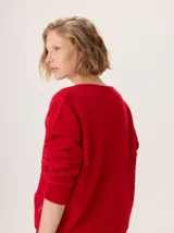 Buzo de lana color marrón topo, con cuello en V y diseño de punto calado en rombos en el frente y mangas.