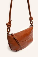 Cartera bandolera de cuero marrón con forma relajada, diseño de costuras curvas y detalles de nudos hechos a mano en las asas.