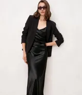 Vestido slip midi satinado color negro, con escote en V, breteles finos regulables y caída fluida.