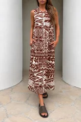 Vestido largo sin mangas, con diseño estampado geométrico y floral en tonos marrón y blanco, de calce suelto y bolsillos laterales.
