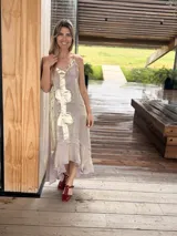 Vestido midi lila con acabado brillante y tirantes finos regulables, diseño con aplicaciones de cuero dorado en el centro y bajo asimétrico con volados.