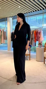 Mono largo negro con escote en V, mangas 3/4 y faja integrada en la cintura.