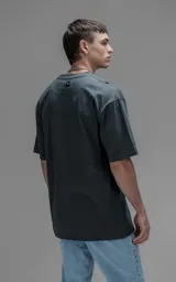 Remera de corte relajado y silueta amplia, con hombros caídos y mangas cortas. Confeccionada en algodón premium, presenta un diseño liso en color gris oscuro.